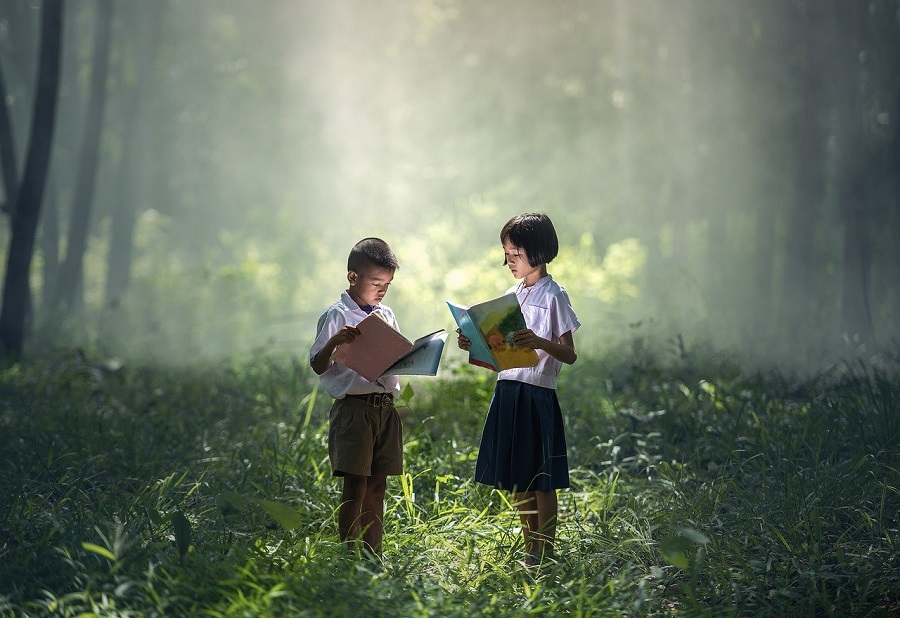 bambini leggono nel bosco